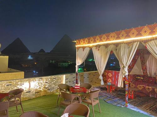 um pátio com uma mesa e cadeiras à noite em Arena pyramids view no Cairo