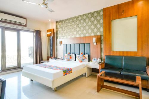 una camera con letto, divano e sedia di FabHotel Prime Devanshi Inn a Kalamboli