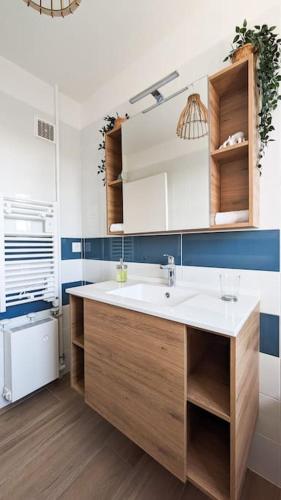 une salle de bain avec un lavabo et un miroir dans l'établissement La Brise du Clos , Grand 3 pièces, Piscine & Tennis, à Villers-sur-Mer