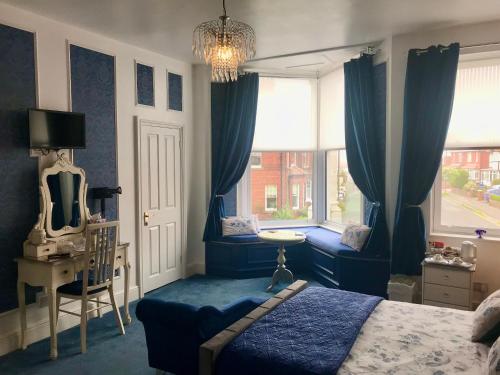 1 dormitorio con cortinas azules, 1 cama y ventana en Norman Guest House with Free Parking, en Whitby