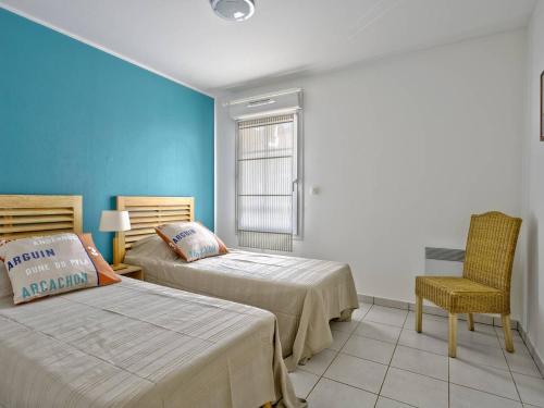 ein Schlafzimmer mit zwei Betten, einem Stuhl und einem Fenster in der Unterkunft T3 Confortable à Arcachon Centre avec Loggia, Parking et Clim, à 400m de la Plage! - FR-1-433-120 in Arcachon