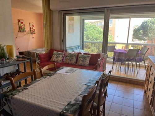 un salon avec une table et un canapé dans l'établissement Appartement T2 avec Garage à Proximité des Plages et Attractions - FR-1-749-65, au Cap d'Agde