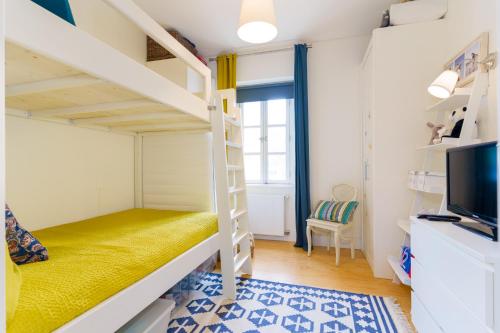 a small bedroom with a bunk bed and a tv at Casa Cima Rio in Alcácer do Sal