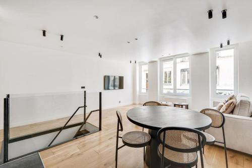un salon avec une table, des chaises et un canapé dans l'établissement Branché Luxueux et Moderne - Réaumur-Sébastopol, à Paris