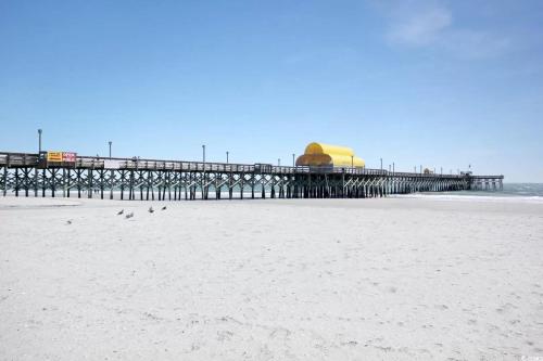 a pier on the beach with birds on the sand at 2BR/2BA Condo at Arcadian Dunes Building 10-238 in Myrtle Beach