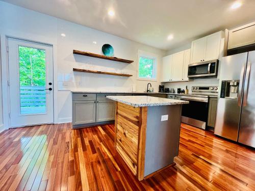 cocina grande con suelo de madera y electrodomésticos de acero inoxidable en Moonlight Ridge, en Asheville