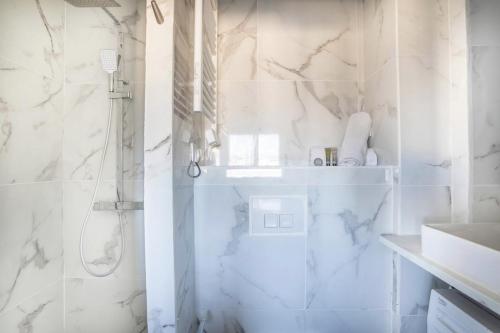 une salle de bain blanche avec une douche et un lavabo dans l'établissement Appt proche plage des Catalans 97CORT1, à Marseille