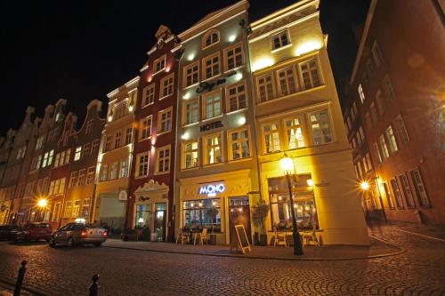 a lit up building on a street at night at Stay inn Hotel Gdańsk in Gdańsk