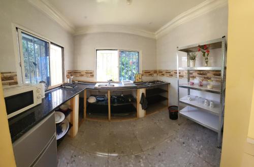 a large kitchen with a sink and a window at Mount Pleasant in Brufut