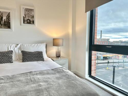Un dormitorio con una cama y una ventana grande. en Apartment No 48 at Citygate, en York