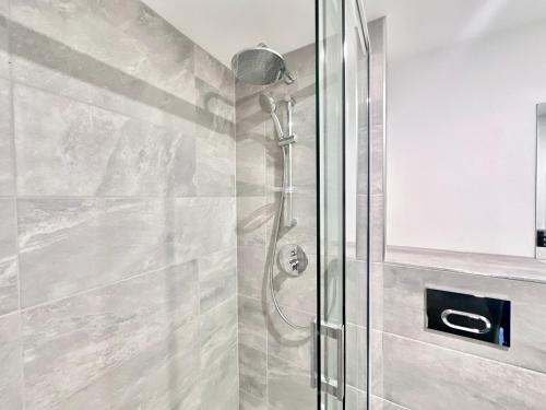 una ducha con puerta de cristal en un baño en Apartment No 48 at Citygate, en York