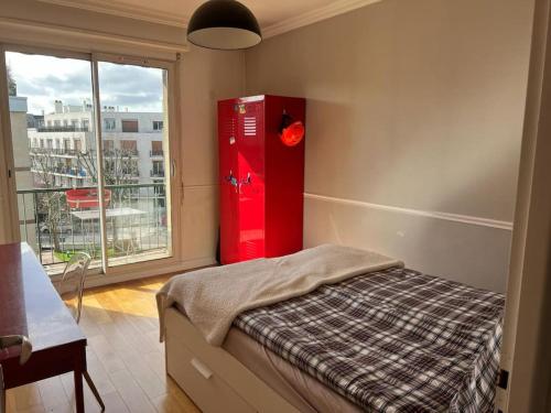 - une chambre avec une armoire rouge et une fenêtre dans l'établissement Special Olympics FlatTerrace Roland Garros View (145 m2 terrasse), à Boulogne-Billancourt