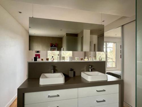 une salle de bain avec deux lavabos et un grand miroir dans l'établissement Special Olympics FlatTerrace Roland Garros View (145 m2 terrasse), à Boulogne-Billancourt