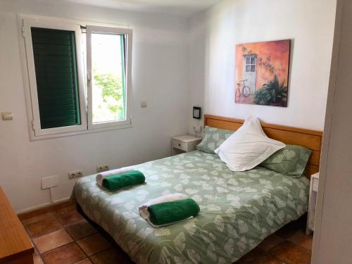 1 dormitorio con 1 cama con 2 almohadas verdes en Bungalow Carmen, en San Bartolomé