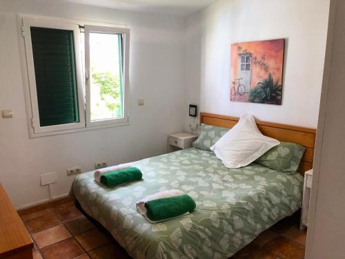 a bedroom with a bed with two green pillows on it at Bungalow Carmen in San Bartolomé