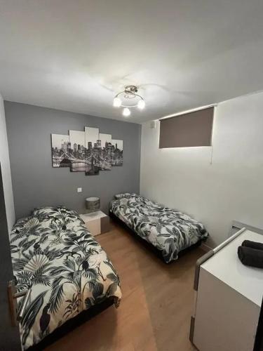 - une chambre avec 2 lits dans une pièce avec un comptoir dans l'établissement Appartement moderne à Aubervilliers - 45 m² - Parking payant, à Aubervilliers
