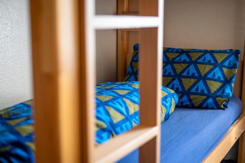łóżko piętrowe z niebieską pościelą i niebieską poduszką w obiekcie Braemar Youth Hostel w mieście Braemar