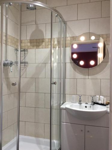 a bathroom with a shower and a sink and a mirror at Bedford Hotel in Tavistock