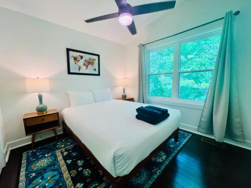 a bedroom with a white bed and a window at Hidden Paradise in Asheville