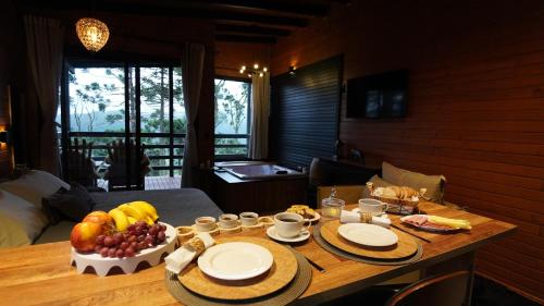 a table with plates of fruit on it in a room at Vale Dourado Cabanas in Urubici