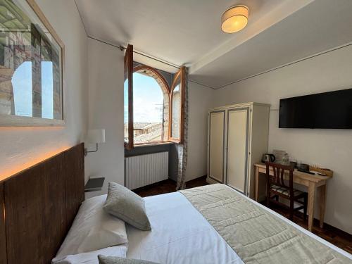Schlafzimmer mit einem Bett, einem Fenster und einem Schreibtisch in der Unterkunft Hotel La Fortezza in Assisi