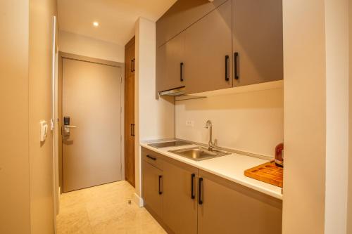 uma cozinha com armários brancos e um lavatório em Montenegro Lodge em Tivat