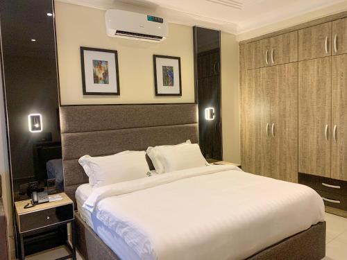 a bedroom with a large white bed in a room at Five Homes Hotel and Apartments in Abuja