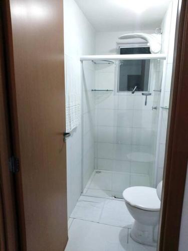 a white bathroom with a toilet and a sink at Apto Ipojuca Caruaru in Caruaru