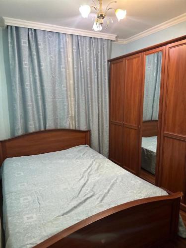 ein Schlafzimmer mit einem Bett, einem Schrank und einem Fenster in der Unterkunft Юнусабад 13 корзинка 