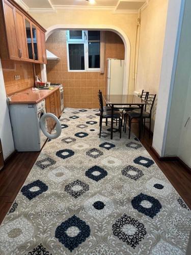 eine Küche mit einem Tisch und Stühlen sowie eine Küche mit einem Teppich in der Unterkunft Юнусабад 13 корзинка 