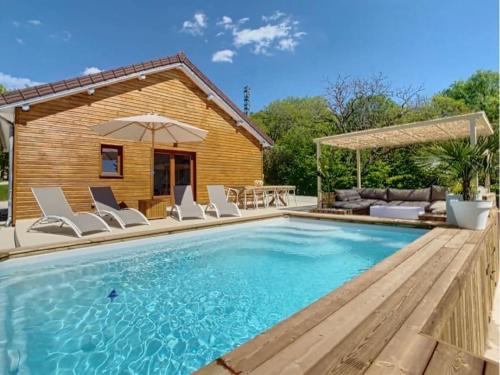 une piscine avec des chaises et un parasol à côté d'une maison dans l'établissement Domaine privé avec piscine et terrain de pétanque, à Viéville