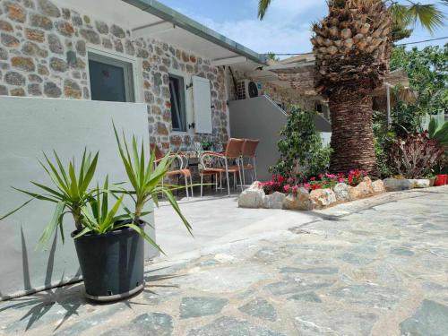 a house with a patio with plants and a table at Voula Ilias Studios in Panormos Kalymnos