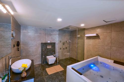 a bathroom with a tub and a sink and a toilet at Serene Horizon in Thekkady