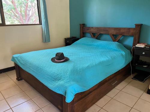 a hat sitting on a bed with a blue sheet at Tucan Studio Ocotal in Coco