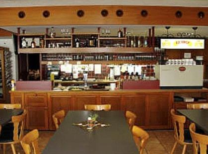 Hotel zum Roten Löwen في Hildisrieden: مطعم بطاولة وكراسي وبار