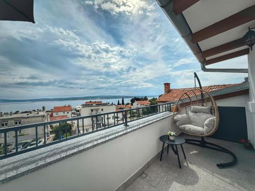 a balcony with a chair and a view of the water at Knežević Apartments in Crikvenica