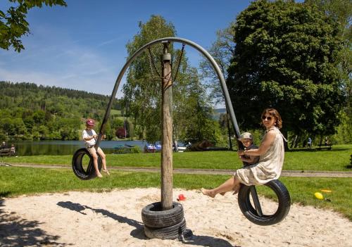 a woman and a child playing on a playground at Feriendorf am Maltschacher See in Feldkirchen in Kärnten