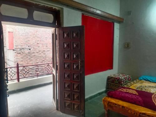uma porta aberta para um quarto com uma cama e uma janela em Jsky em Ujjain