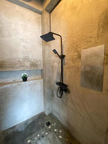 a shower with a light on the corner of a room at Katre Siargao - SELF CHECK-IN Budget Hostel in San Isidro