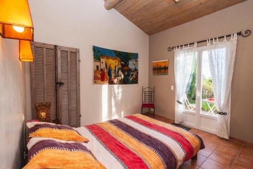 une chambre avec un lit et une fenêtre dans l'établissement Le Mas de l'Aven, à Aups