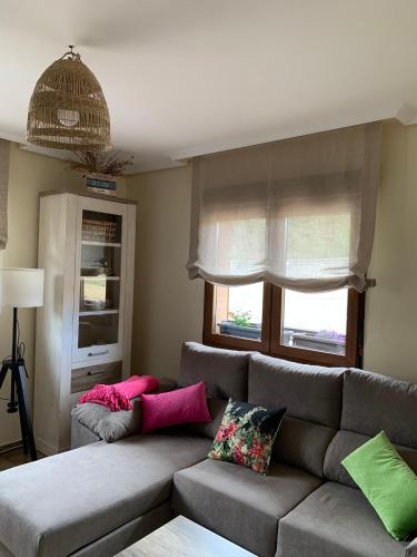 a living room with a gray couch with colorful pillows at El Hoyaco in Los Espejos de la Reina