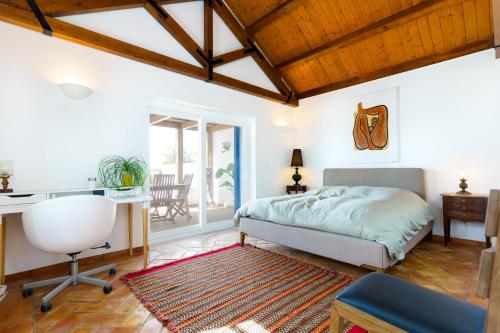 una camera da letto con un letto, una scrivania e una sedia di Salento ad Alcácer do Sal