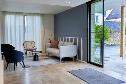 a living room with a couch and a chair at Quality Hotel La Marebaudière Vannes Centre in Vannes