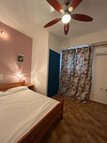 a bedroom with a bed and a ceiling fan at Ilios Kalamaki in Kalamaki Heraklion