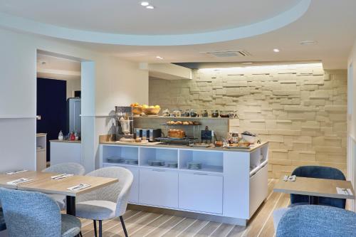 a kitchen with a counter and a table and chairs at Quality Hotel La Marebaudière Vannes Centre in Vannes