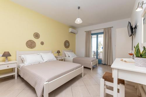 a bedroom with a bed and a couch and a table at Hotel Francesca in Agios Prokopios