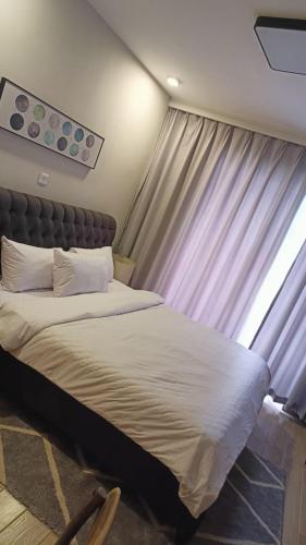a large bed in a room with a window at InDesign Makumbi Park Apartments near 67 airport hotel in Syokimau