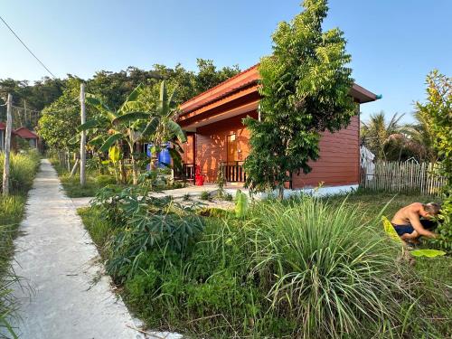 a man sitting in front of a house at Maloop Cafe Bungalow in Koh Rong Island