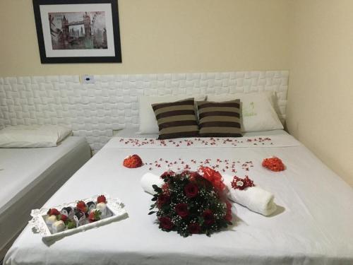 a bed with flowers and decorations on it at Pousada Villa Bella in Palmeiras