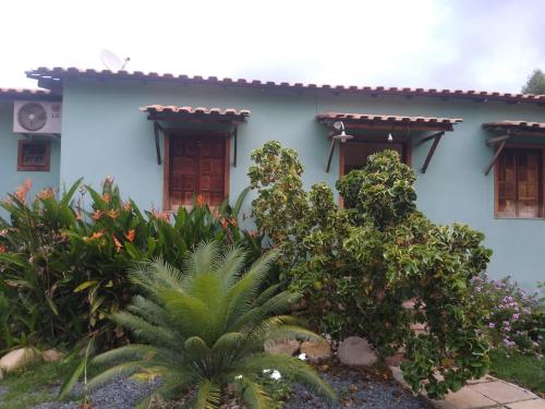 a blue house with plants in front of it at Pousada Villa Bella in Palmeiras